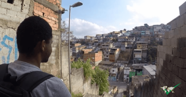 Jovens estudantes sorrindo ao redor de um notebook